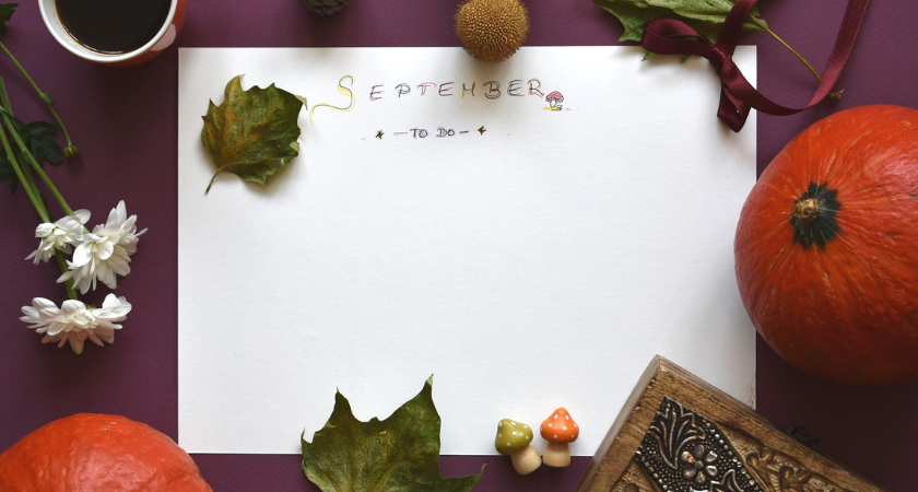 a piece of paper with September written on it, surrounded by fall decor